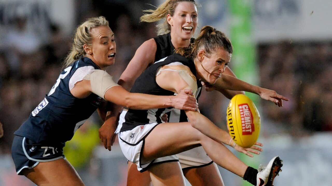 Alicia Eva of Collingwood gets her kick smothered by Lauren Arnell of Carlton during the round 1 AFLW match between the Carlton Blues and Collingwood Magpies.