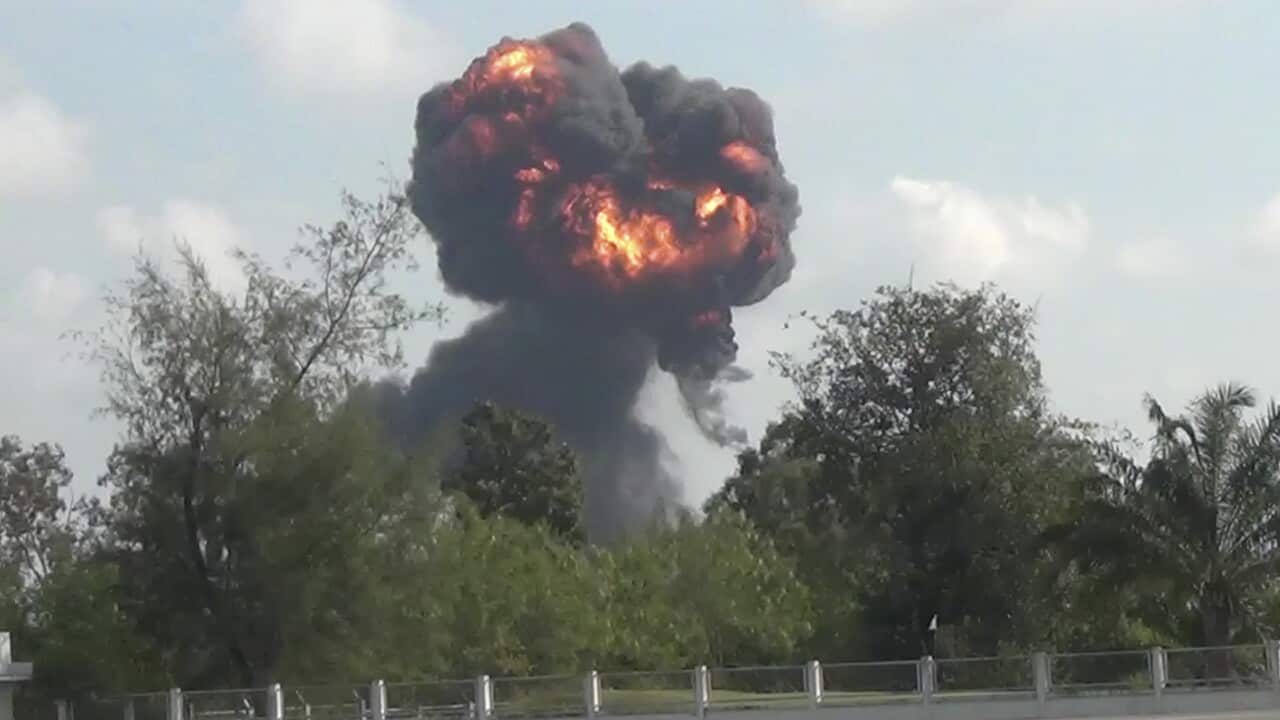 In this image made from video, a plume of smoke and fire rises from the site where a fighter jet crashed during and airshow.