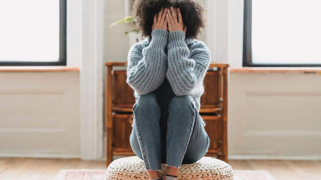 Faceless unhappy woman covering face