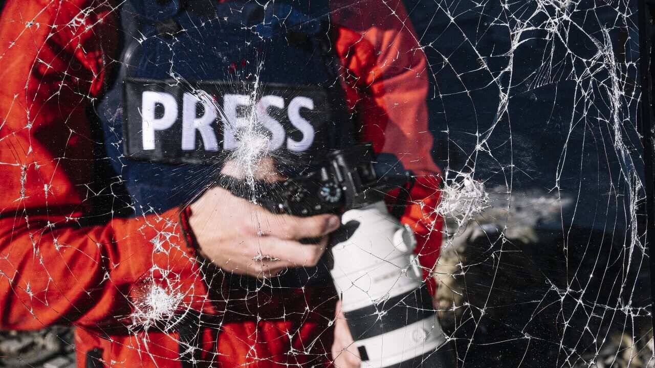 One man, war journalist with digital camera at the place of action, in war zone.