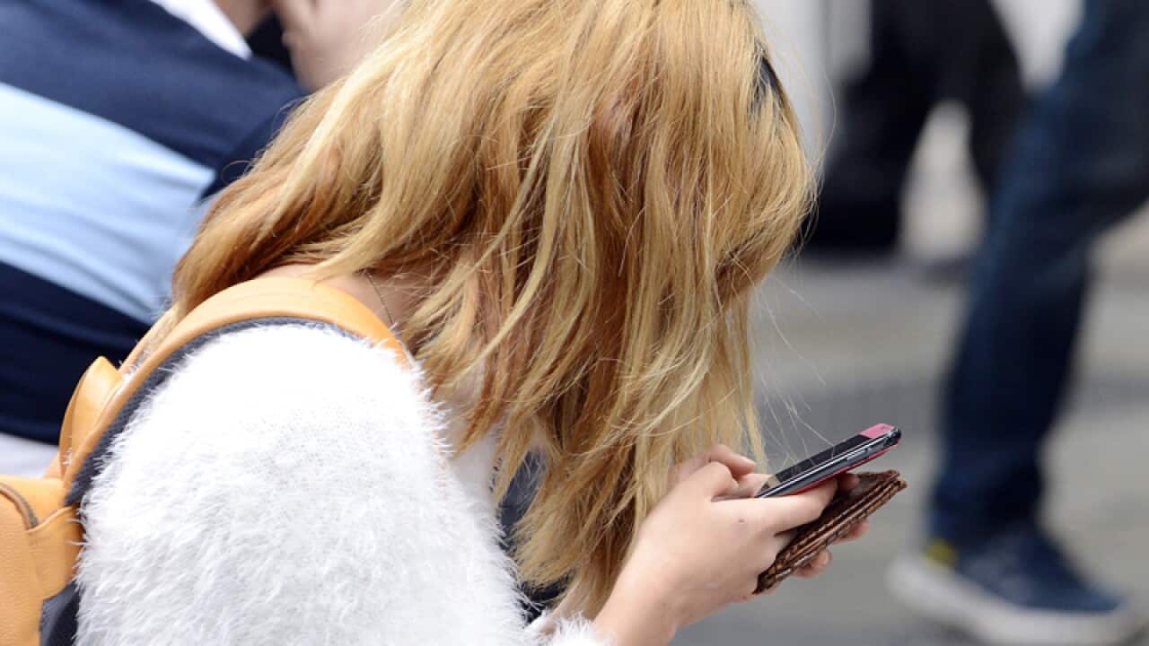 A young woman uses her mobile phone