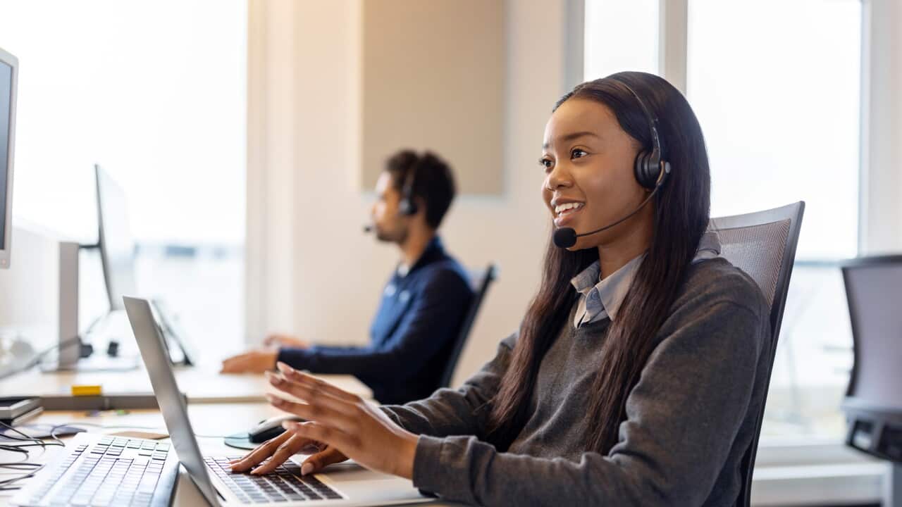 Customer service representative fielding phone calls in office