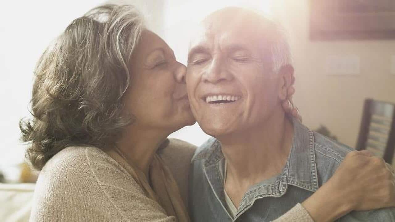 Hispanic couple kissing in living room