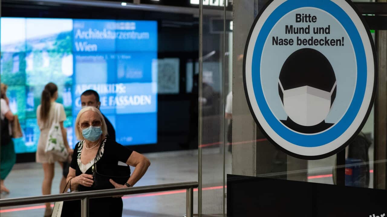 A sign reading Please cover your mouth and nose, at Karlsplatz underground station in Vienna, Austria