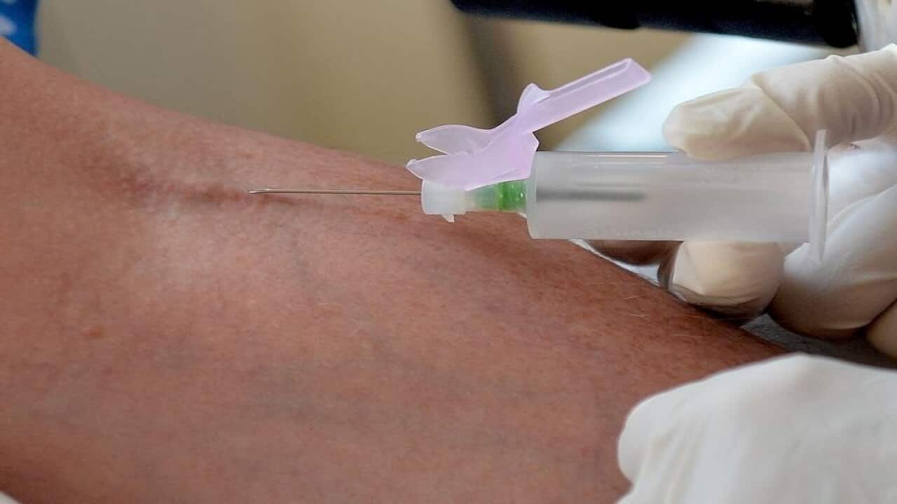 A nurse takes blood from a patient