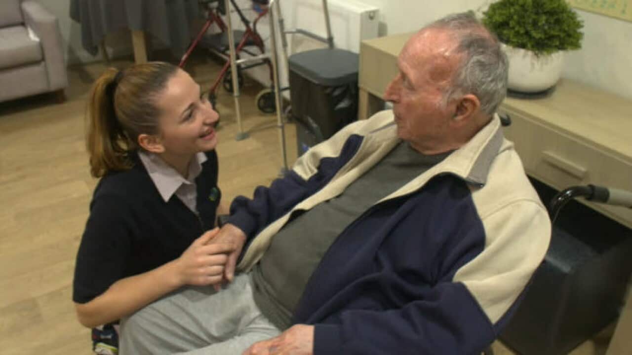 A worker at Fronditha care centre in Melbourne assisting resident – SBS.