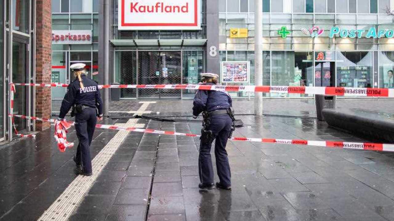 Police walk behind barrier tape on Berlin Square after a man had driven his car into a group of pedestrians and injured at least four.