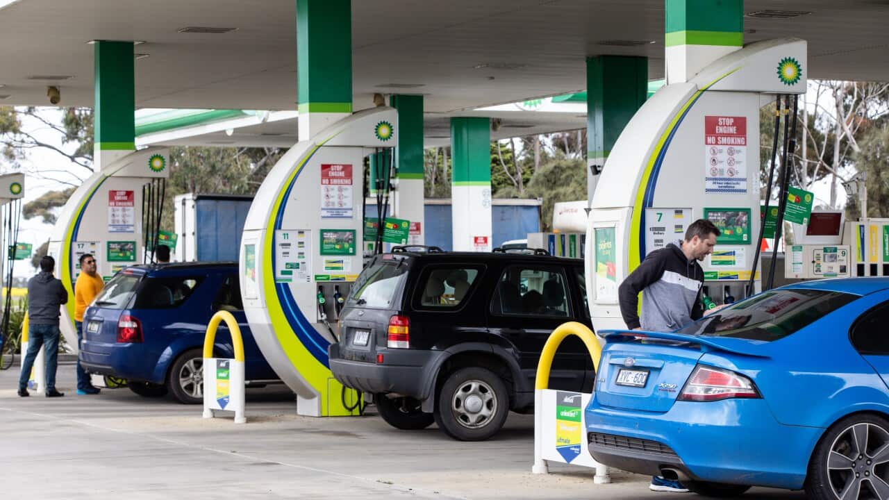 Three cars lined up at a petrol station.