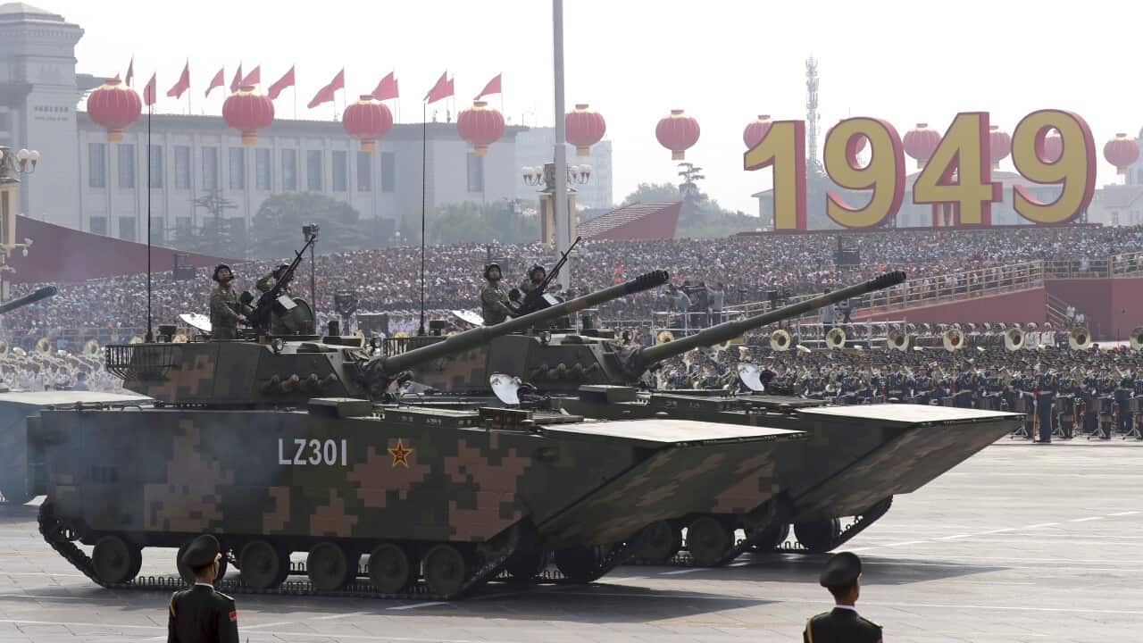 Military vehicles roll down as members of a Chinese military honor guard march during the parade to commemorate the 70th anniversary of the founding of Communist China in Beijing, Tuesday, Oct. 1, 2019. (AP Photo/Ng Han Guan)