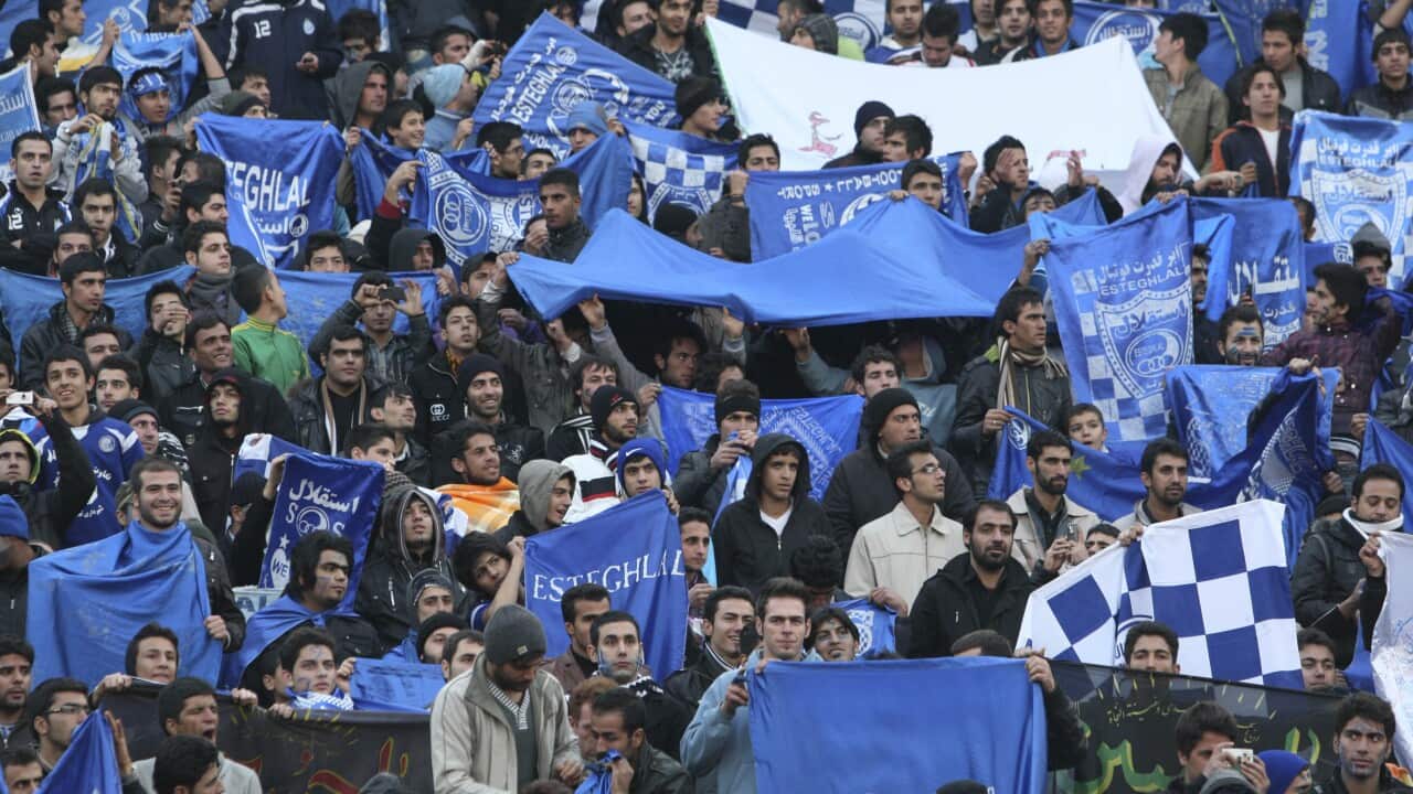 Supporters of Iranian soccer team Esteghlal, hold flags of their favorite team, at the Azadi (Freedom) stadium, in Tehran, Iran.