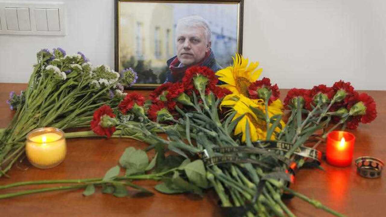 A portrait of Pavel Sheremet is surrounded with flowers and candles at the Radio Vesti headquarters in Kiev, Ukraine