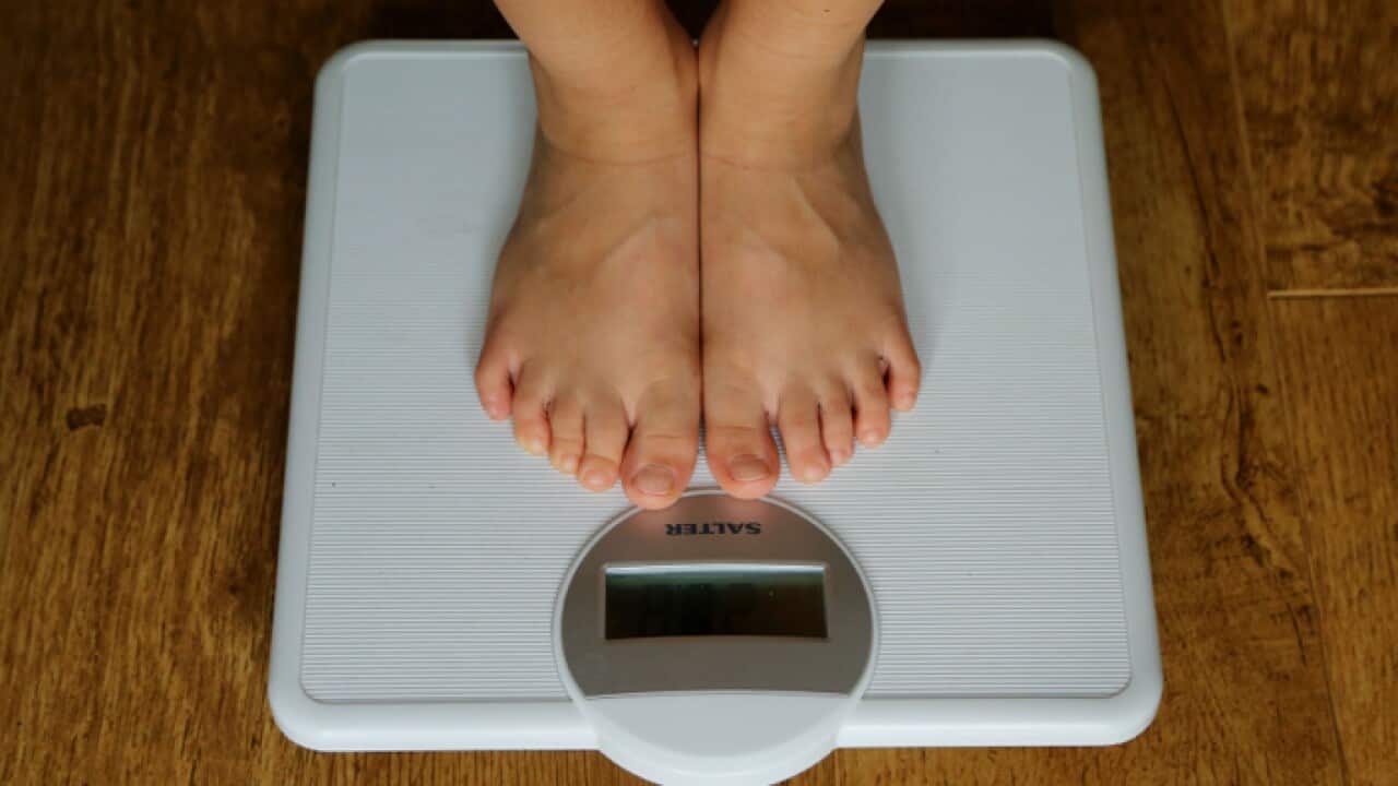 A person being weighed on scales