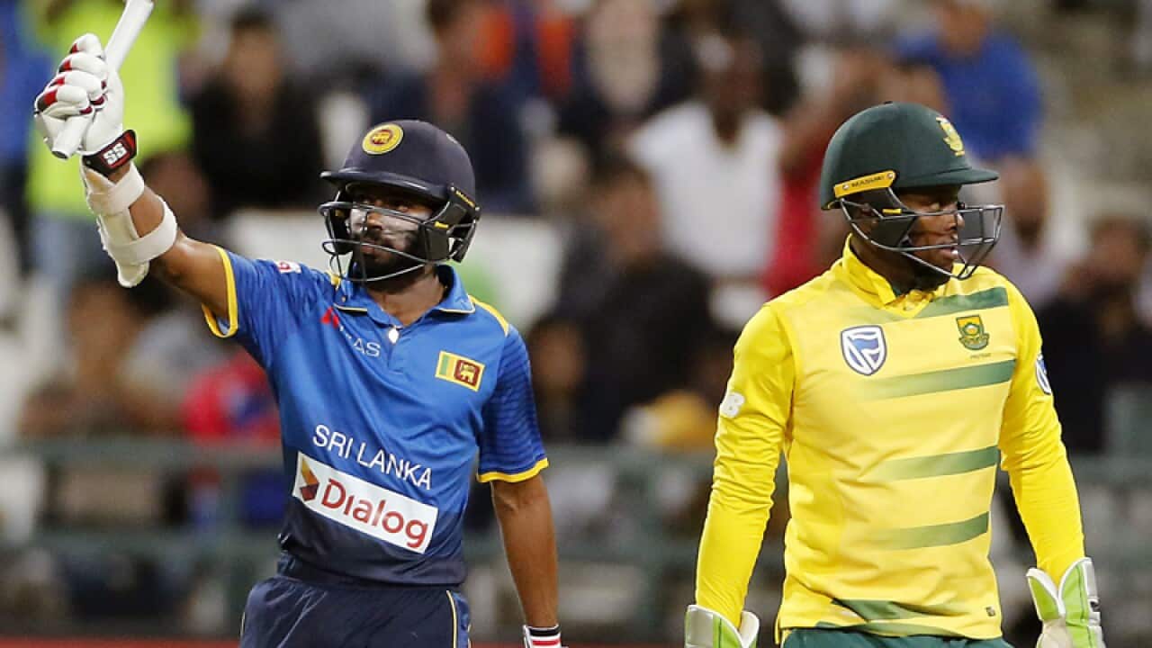 Sri Lanka Niroshan Dickwella, left, holds his bat up