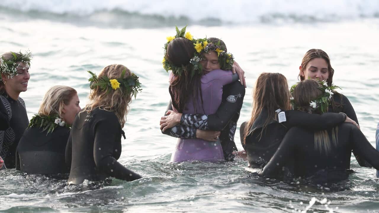 Girlfriend Ellidy Vlug is consoled by friends and family during the 'Paddle Out For Chumpy' event.