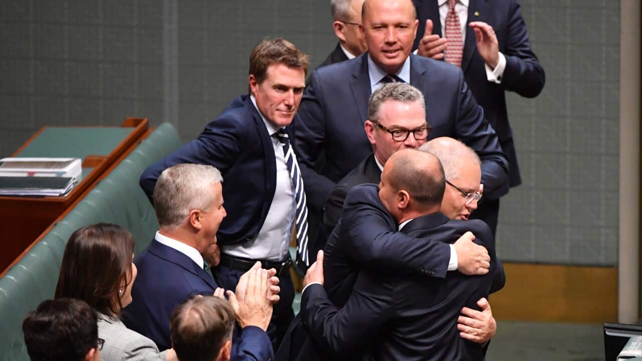 Prime Minister Scott Morrison hugs Treasurer Josh Frydenberg after handing down his first Federal Budget in the House of Representatives at Parliament House in Canberra, Tuesday, April 2, 2019. (AAP Image/Mick Tsikas) NO ARCHIVING