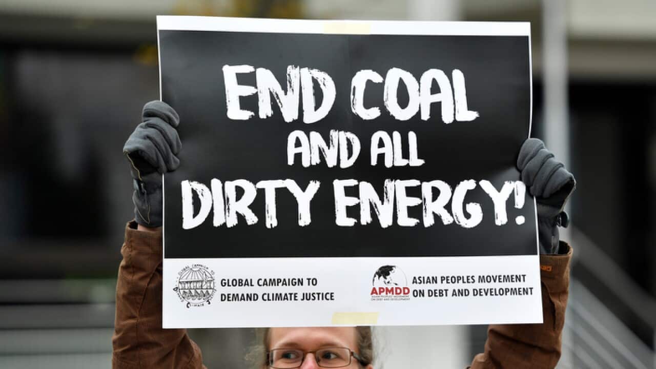 A protestor holds a sign demanding to end coal burning during climate talks in Bonn, Germany.