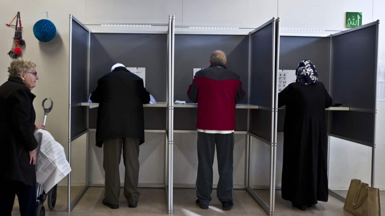 People fill out ballots prior to casting their votes