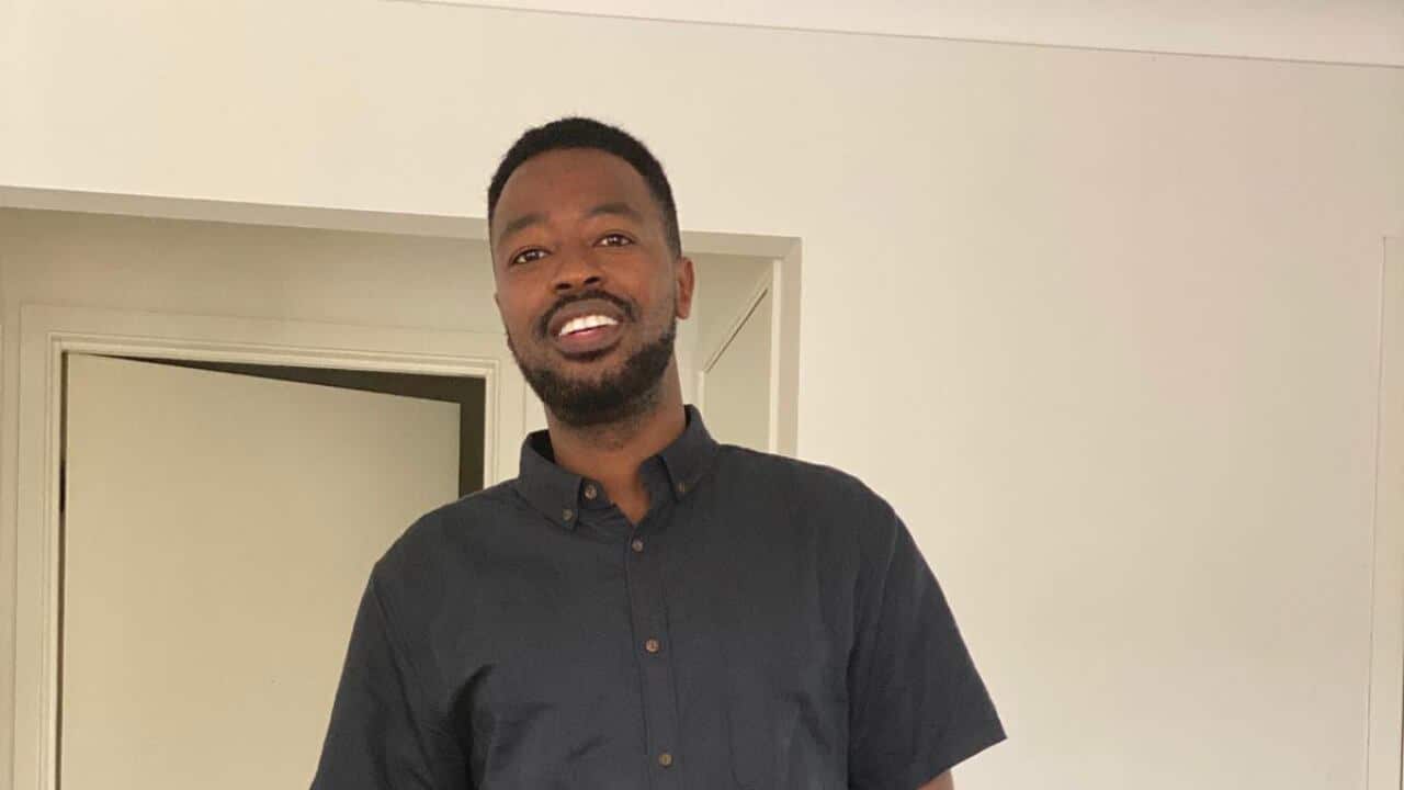 Nzoyihaya Ildephonse ahagaraye imbere y'umuryango.