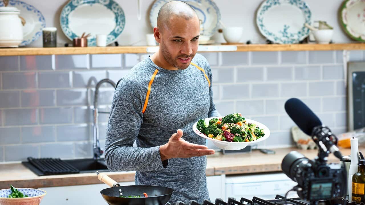 A man holding vegetarian food and talking to video camera