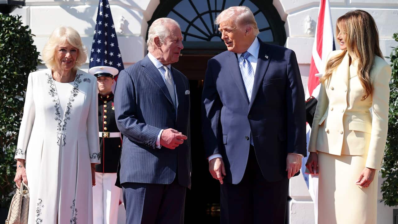 King Charles III and Donald Trump stand together on a red carpet outdoors, flanked by Queen Camilla and Melania Trump.