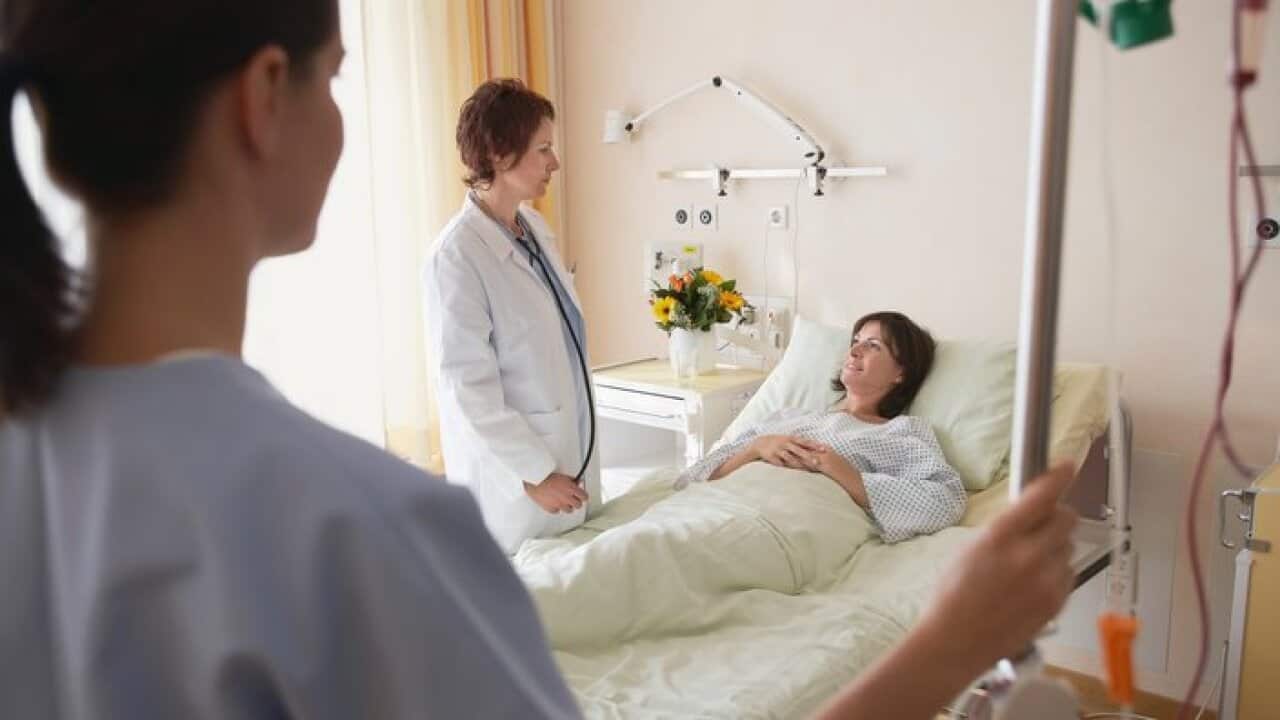Doctor and Nurse With Patient in hospital room