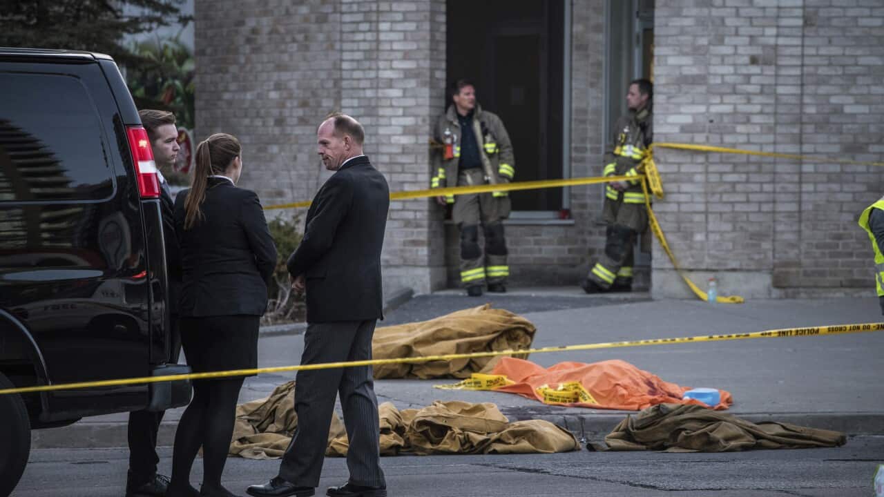 A coroner waits to remove a dead body from the sidewalk after a driver plowed a rented van along a crowded sidewalk, killing multiple people and injuring others, Monday, April 23, 2018, in Toronto. (Aaron Vincent Elkaim/The Canadian Press via AP)