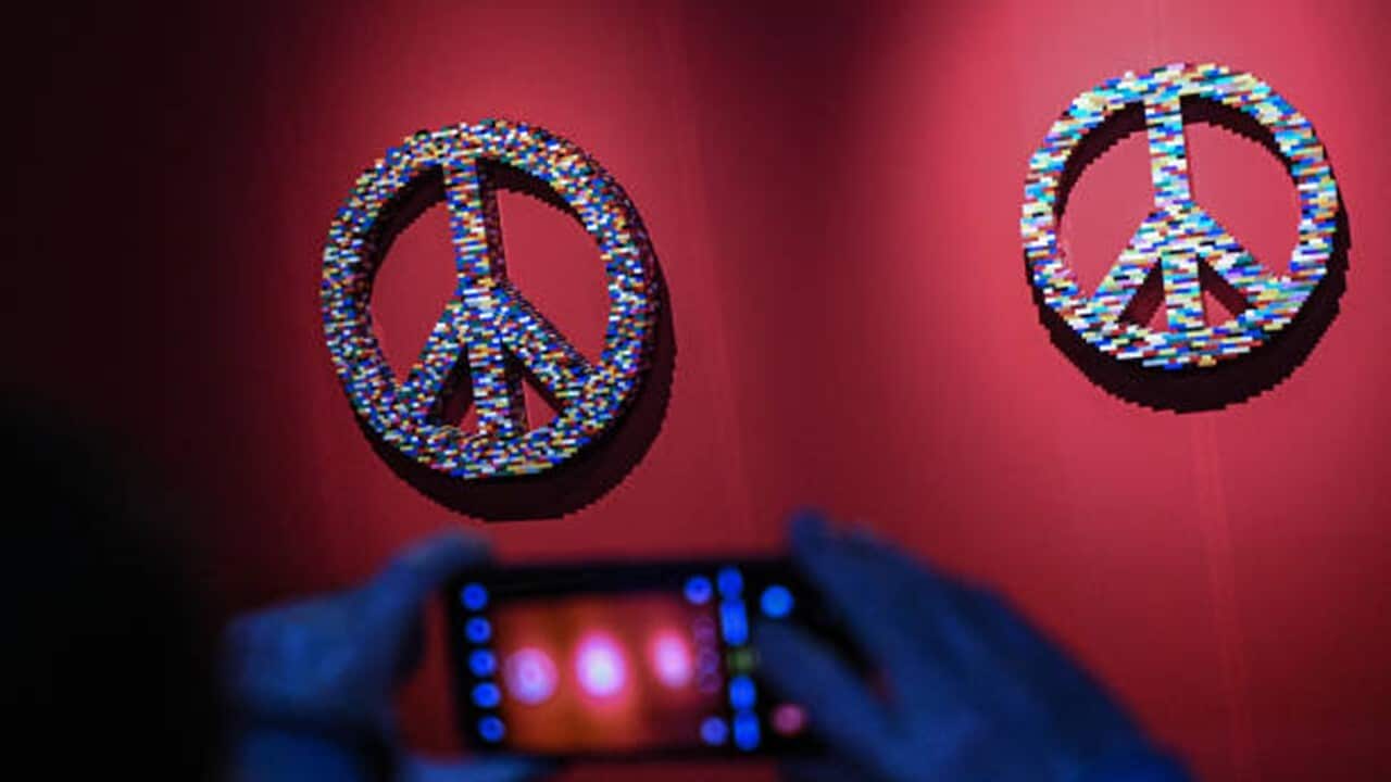 A guest looks at an artwork made with LEGO entitled 'Peace Symbol' during 'The Art of the Brick' exhibition by Nathan Sawaya.jpg
