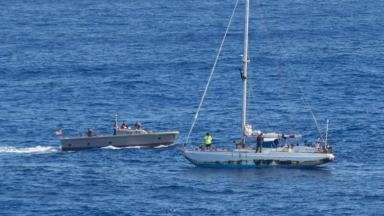 Sailors assigned to the amphibious dock landing ship USS Ashland manoeuver to render assistance to distressed mariners