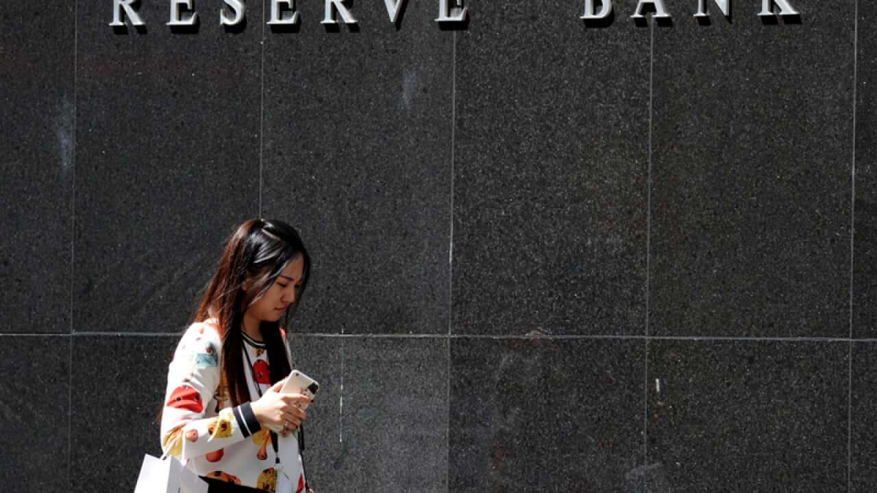 A pedestrian walks past the Reserve Bank of Australia