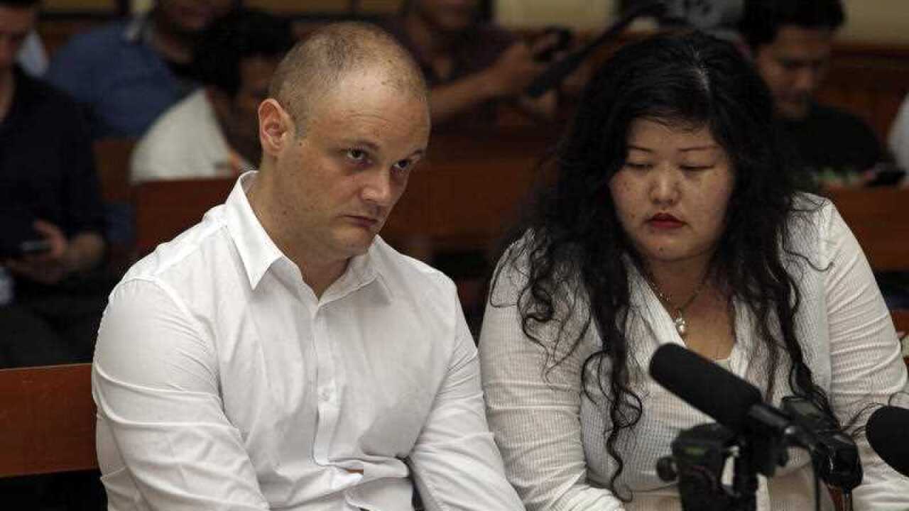 Australia national Isaac Roberts, left, listens to an Indonesian interpreter during his first appearance in Denpasar district court in Bali, Indonesia, Monday, Feb. 12, 2018.