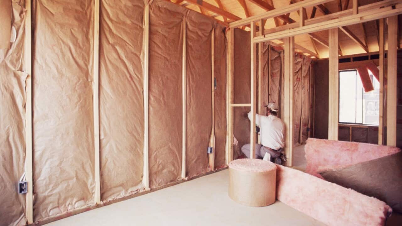 Installing insulation into wall of new home