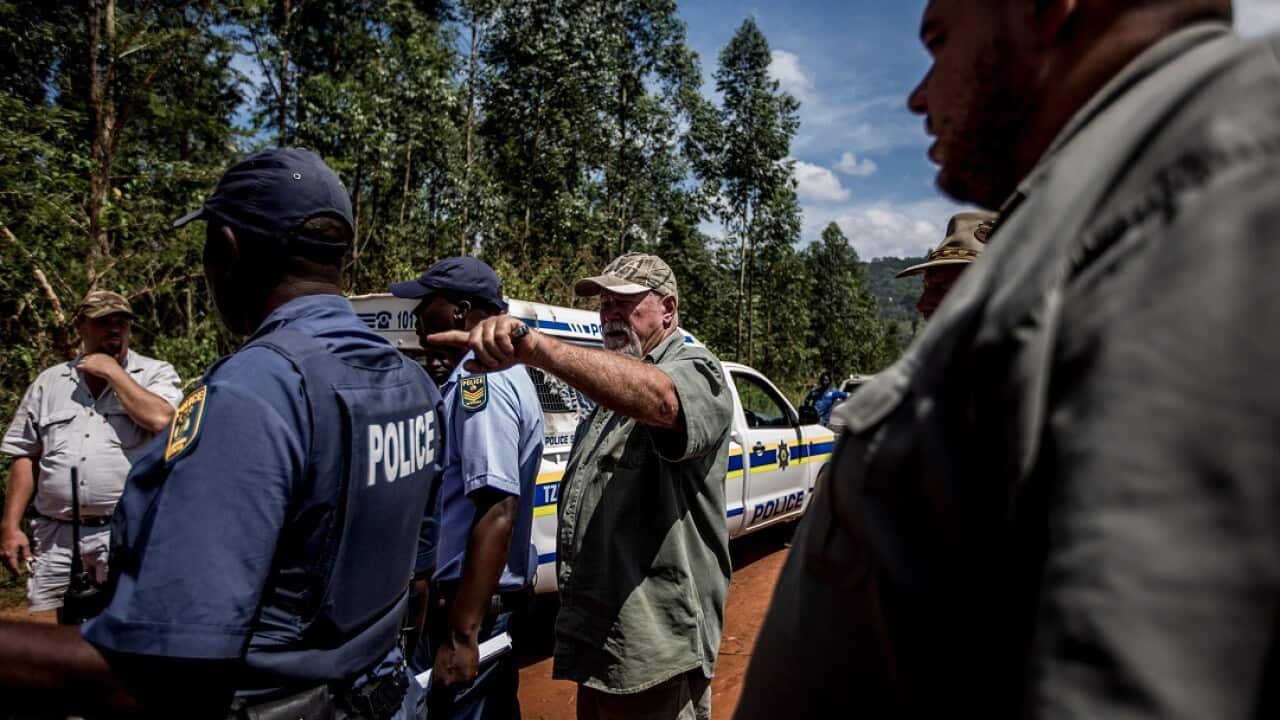 A farmer speaks to South African police after an incident in which a farm worker was held at gunpoint.