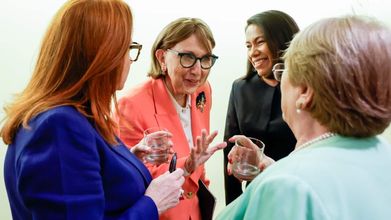 Four women smiling and talking.