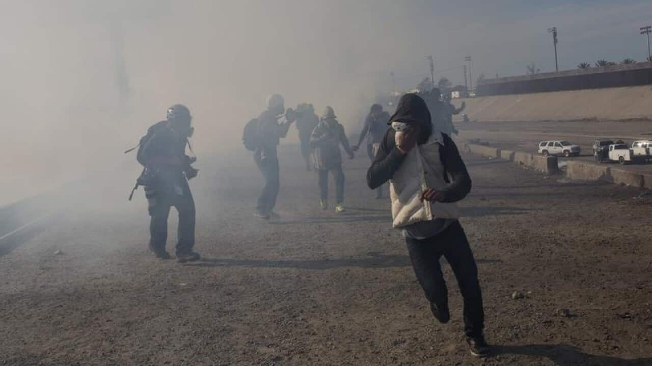 US agents launched gas canisters at migrants attempting to breach the border fence with Mexico.