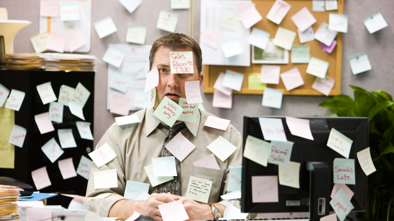 businessman covered in reminder notes