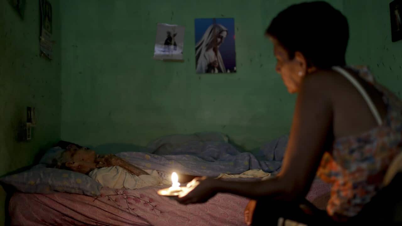 Ninoska Blanco sits beside her sick mother Alexandrian Blanco at her home in Caracas, Venezuela.