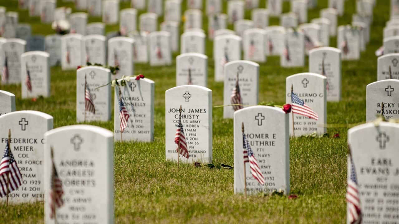 Roses and US flags adorn the graves of the fallen at Arlington