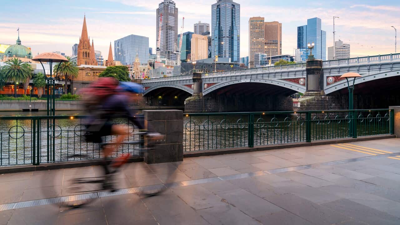 Australian people cycling for exercise near Yarra River with view of the Melbourne City Financial District with skyscrapers in morning at Melbourne, Victoria, Australia.