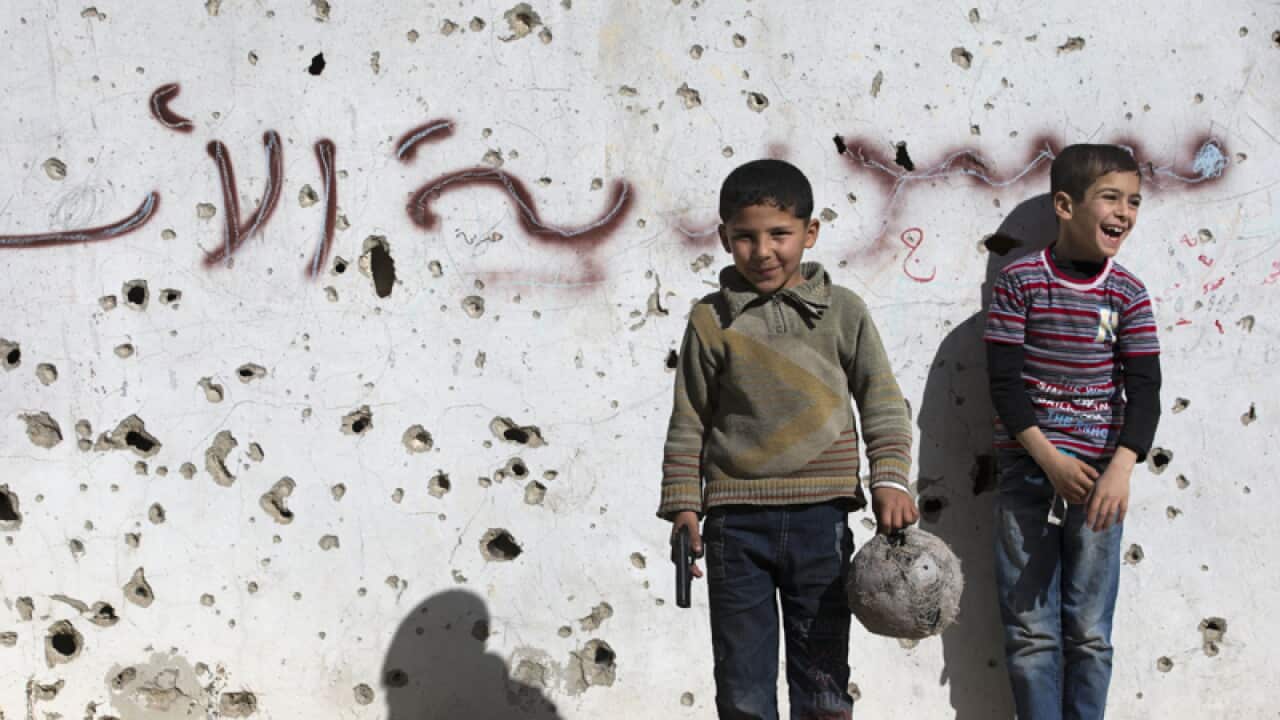 Syrian boys play in the city of Homs, Syria