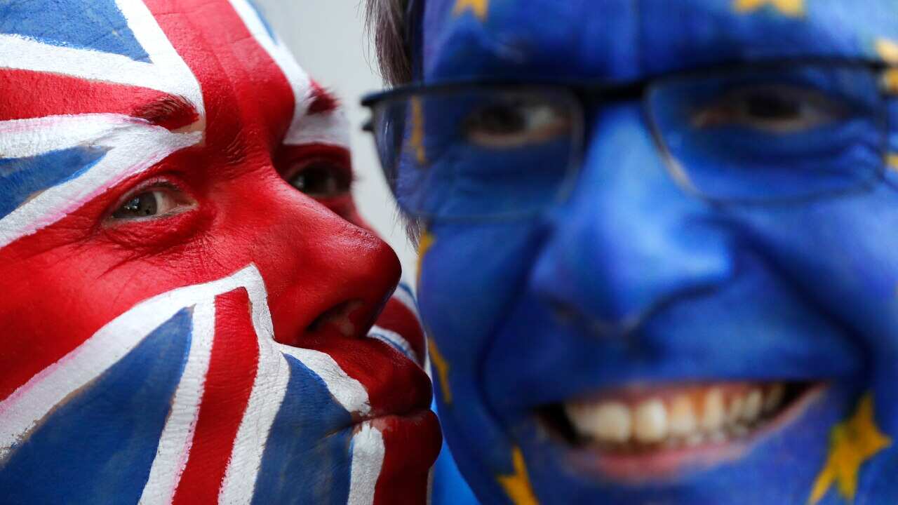 Activists poses with their faces painted in the EU and Union Flag colors during an anti-Brexit campaign stunt outside EU headquarters.