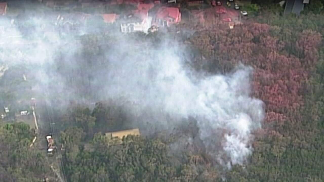 Fire burn dangerously close to homes which have been covered in fire retardant on Sydney's north shore.