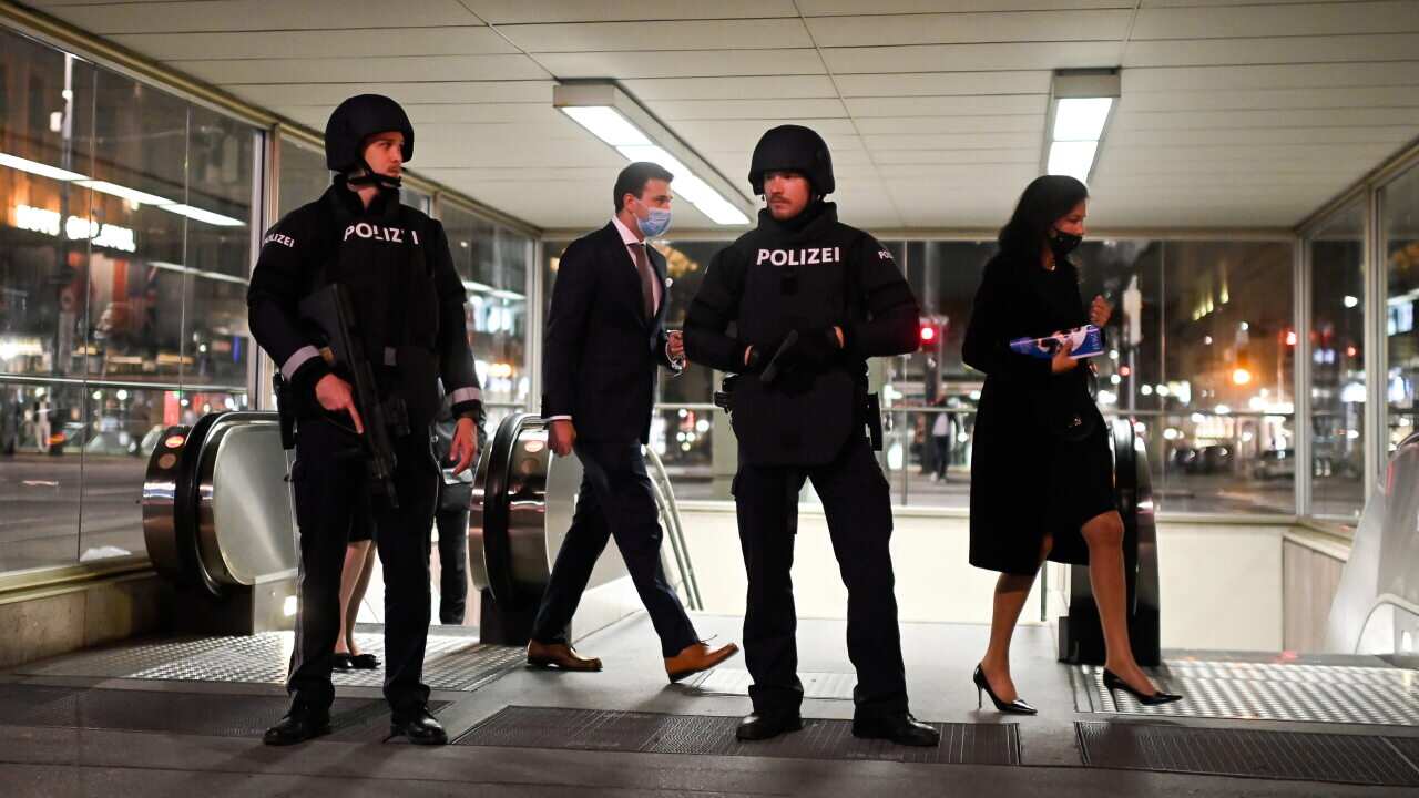 Austrian police guard visitors at Vienna State Opera as they leave a subway station after the attack.