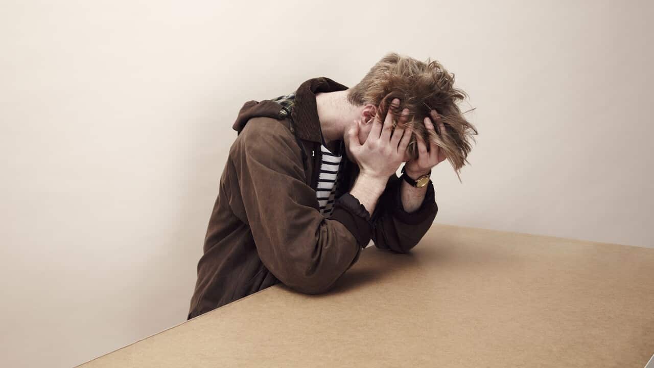 Portrait of man with his head in his hands