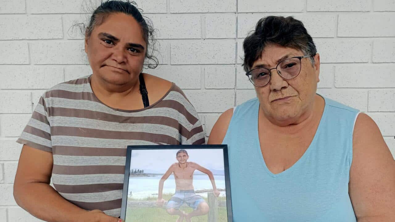 2. George’s mother Karen Campbell (L), and George’s grandmother Fay Campbell (R) stand with a picture of George before the coronial inquest. .png