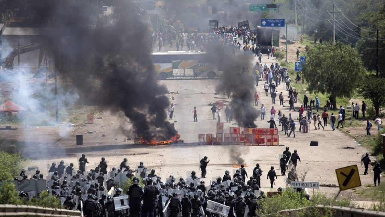 Policemen clash with teacher during a protest in southern Mexico