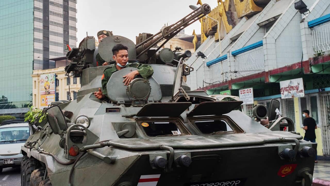 Soldiers in armoured vehicles drive along the street outside Sule Pagoda in Yangon, Myanmar, 14 February 2021.