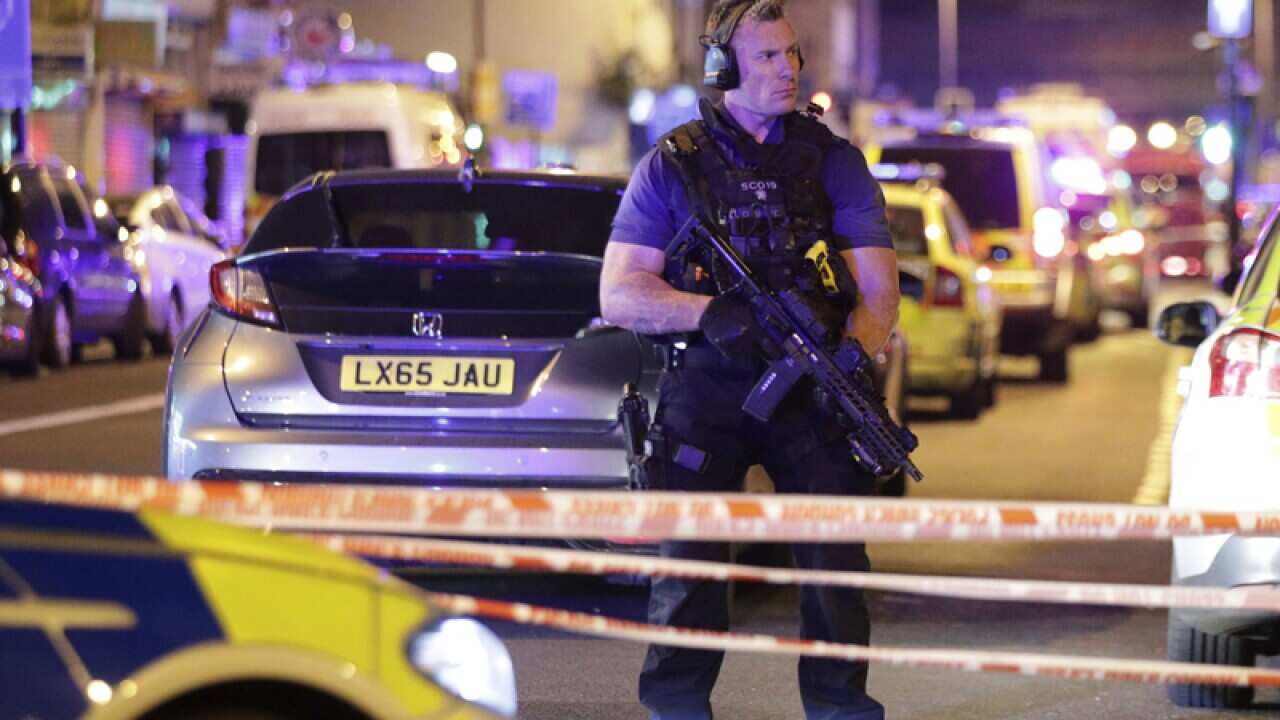 An armed police officer mans a cordon at Finsbury Park in London