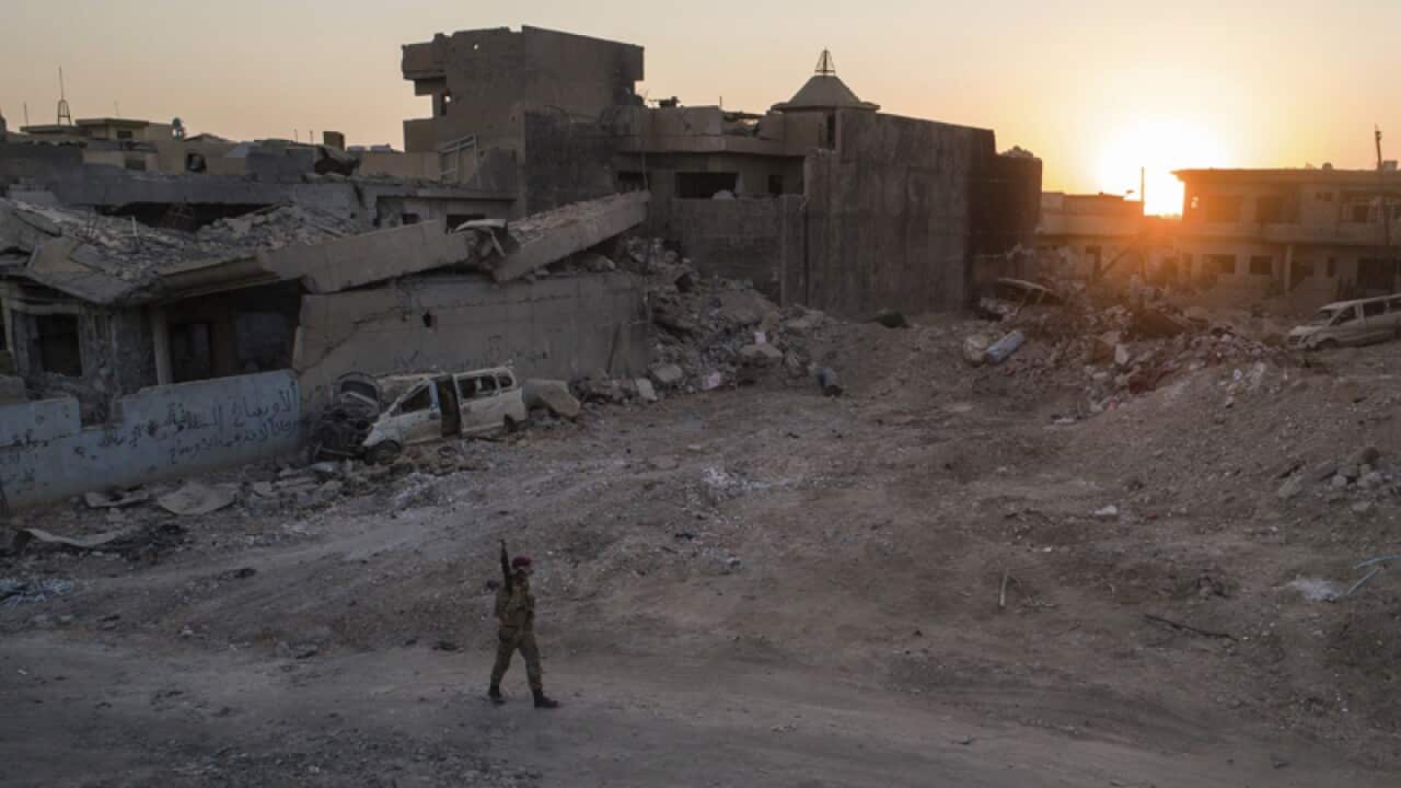 An Iraqi soldier walks in a neighbourhood in west Mosul
