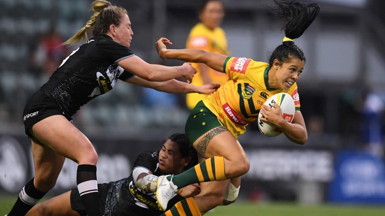 Tiana Penitani of the Jillaroos steps through a tackle by Maitua Feterika of the Kiwi Ferns