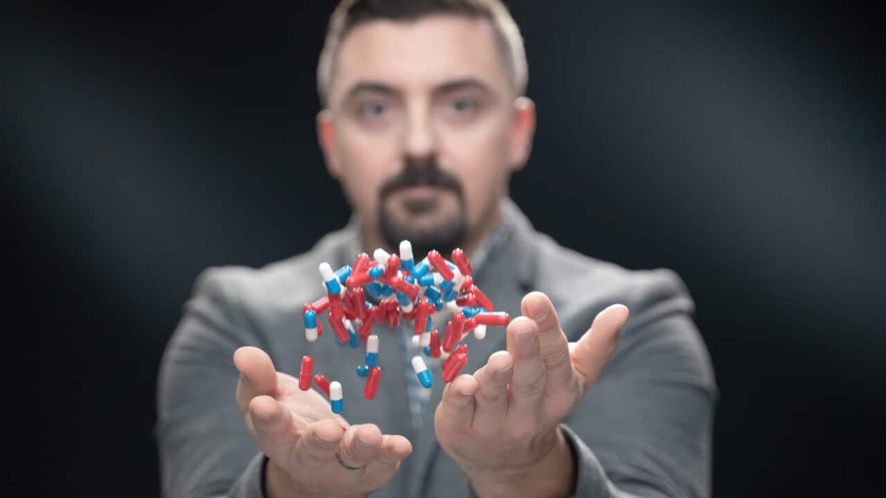 Man throwing mixed color pills in the air